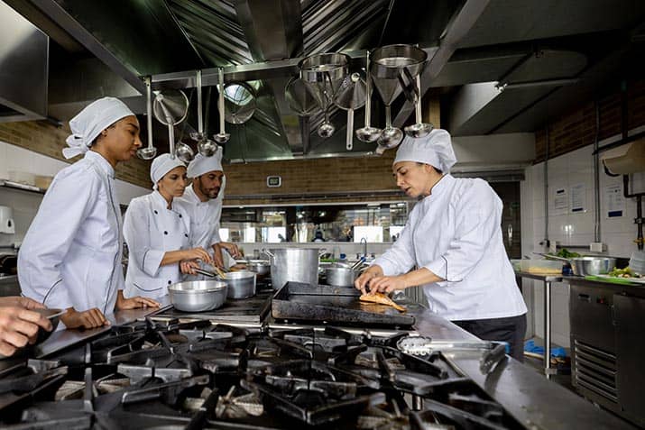 Chef Demonstrates Technique in Restaurant Kitchen